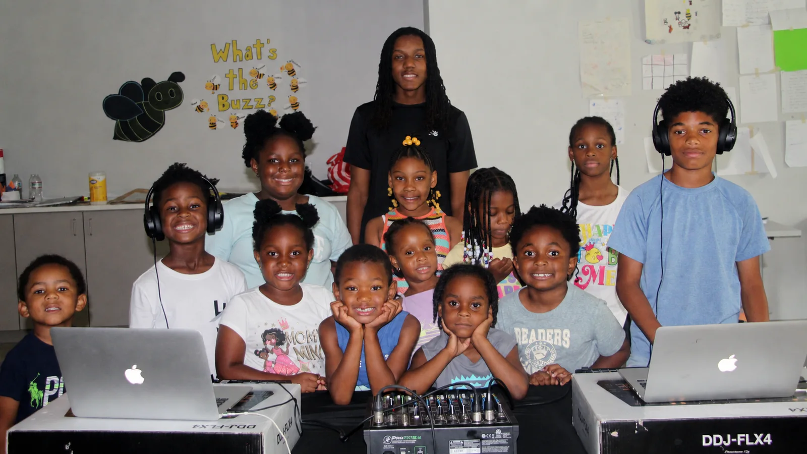 Future of Music students and their instructor gathered behind DJ equipment