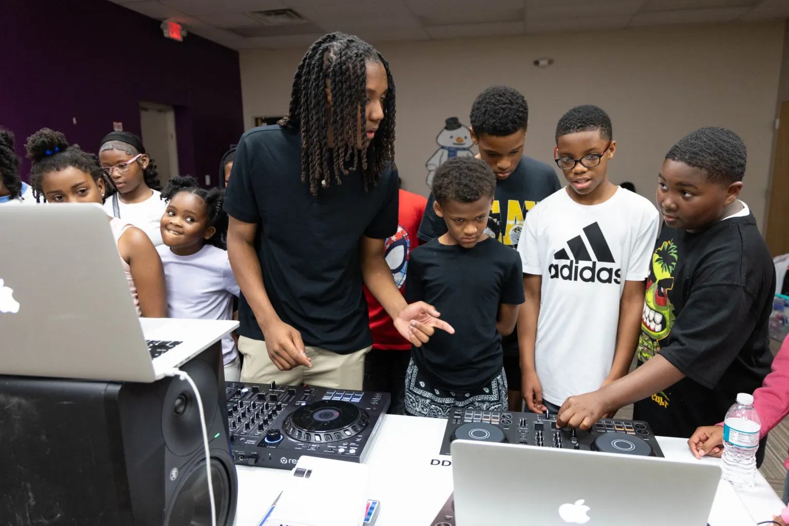Young people learning together around DJ equipment